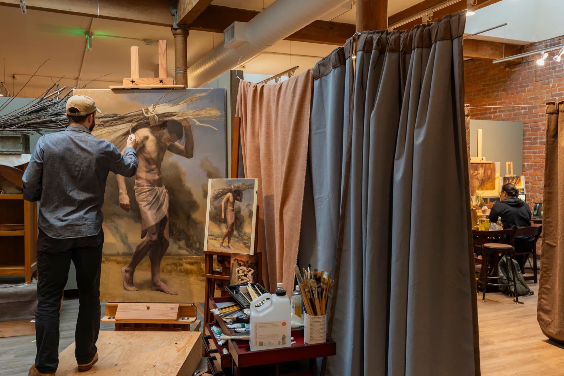 A painter working on a large figure painting during a workshop in the Occidental studios.